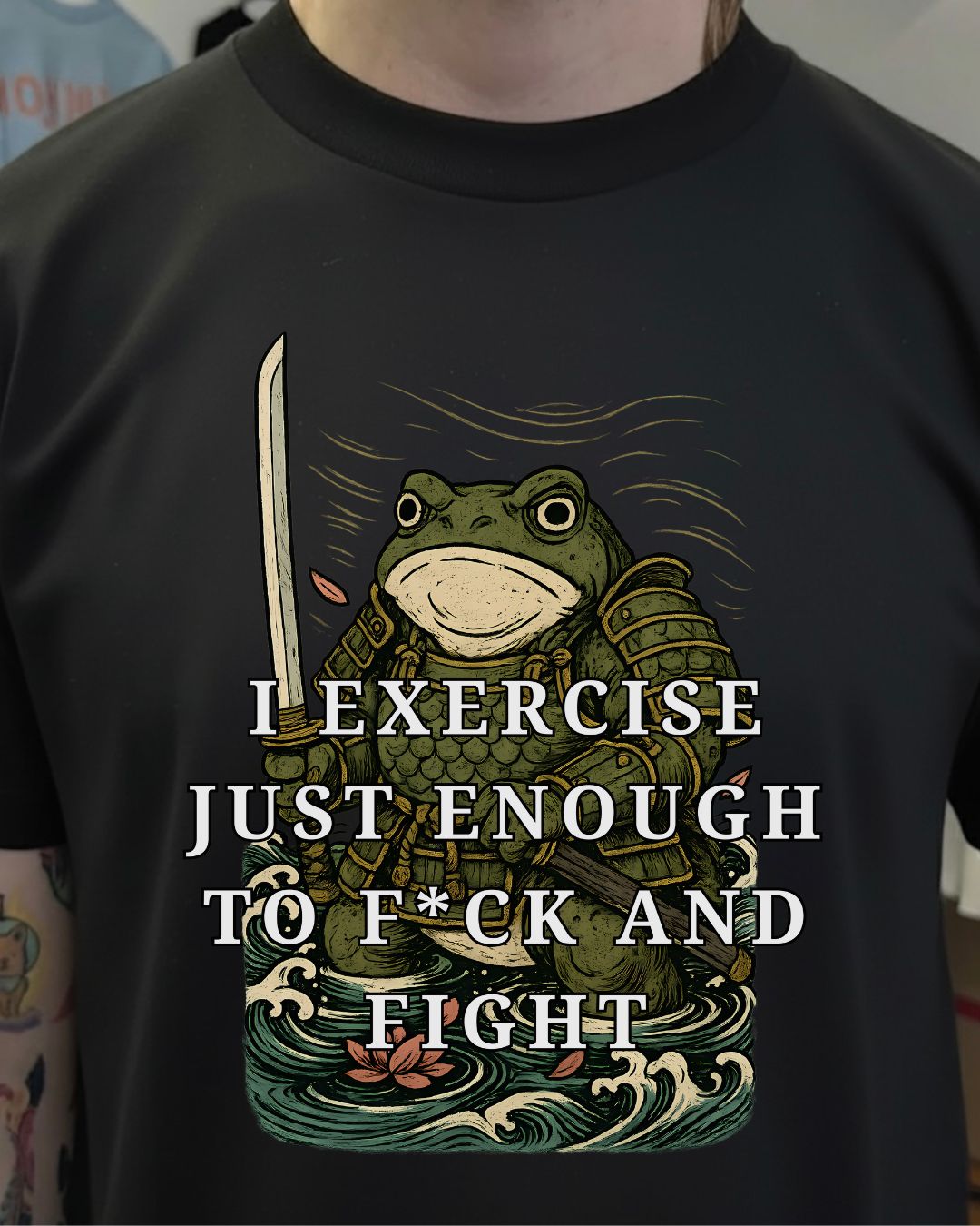 Black t-shirt with a frog design and text on a person wearing it.