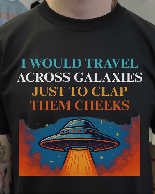 Black t-shirt with a UFO design and humorous text about traveling across galaxies.